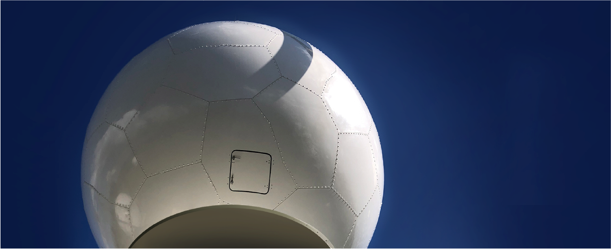 A large white geodesic dome with pentagonal and hexagonal panels, resembling a soccer ball, stands against a clear deep blue sky—showcasing the unique structure’s versatility for various architectural applications.